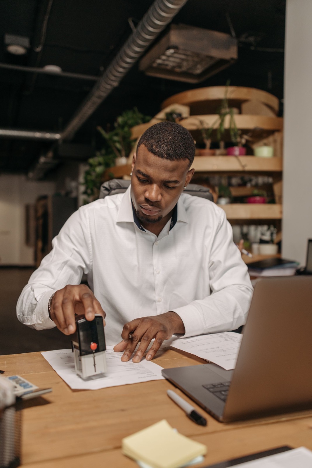 A person stamping an official document at a desk